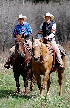 Twin Wranglers ride down a trail